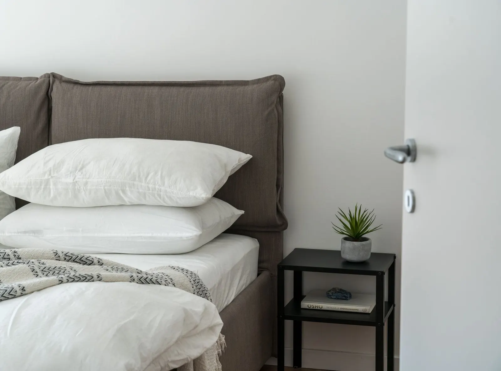 Bed with clean white bedding and a side table