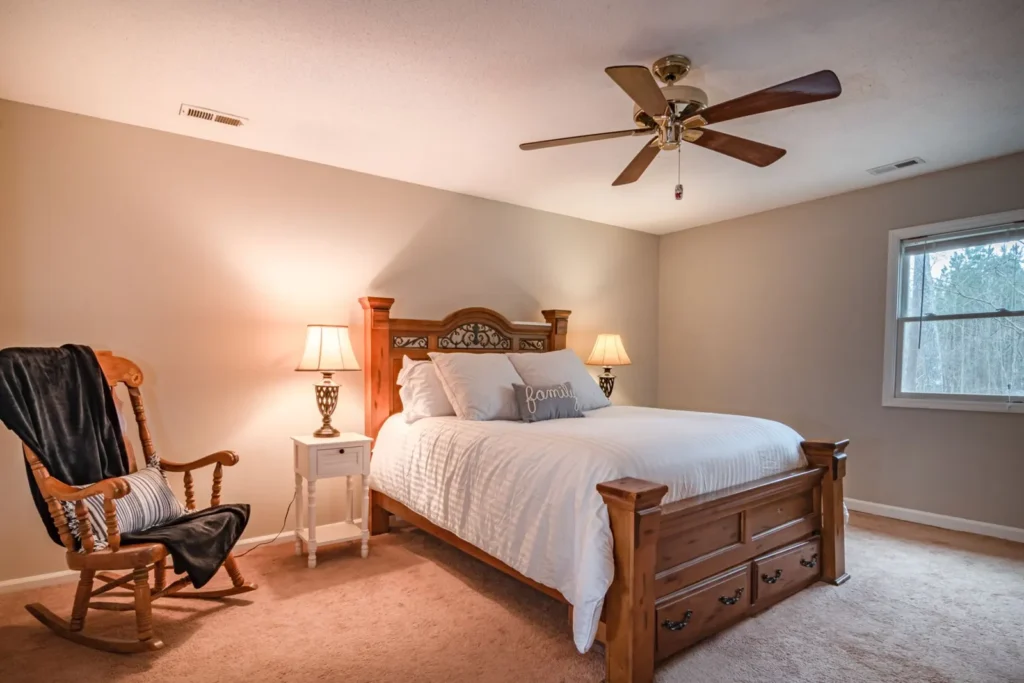 Warm bedroom with a wooden bed and a ceiling fan