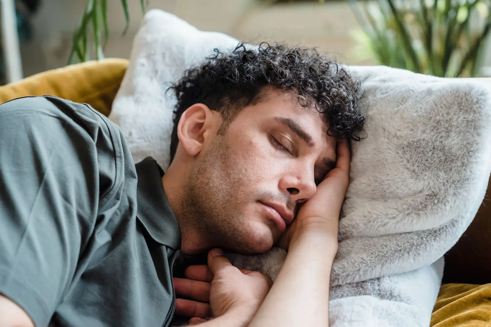 Young man napping on a couch with a soft pillow